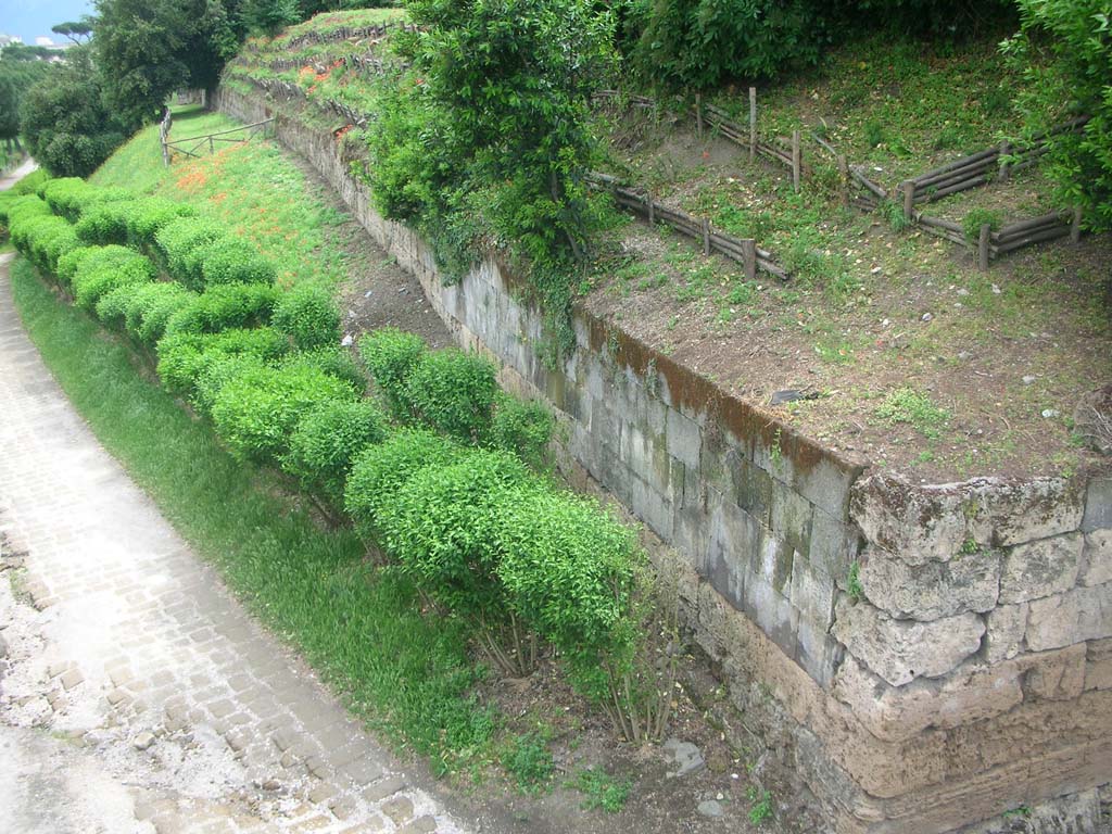 Via dell’Abbondanza. May 2006. Looking south along the city walls at the junction with the Sarno Gate. 
The structure on the left is the modern railway and foot bridge which blocks the ancient route of the Via dell’Abbondanza.
