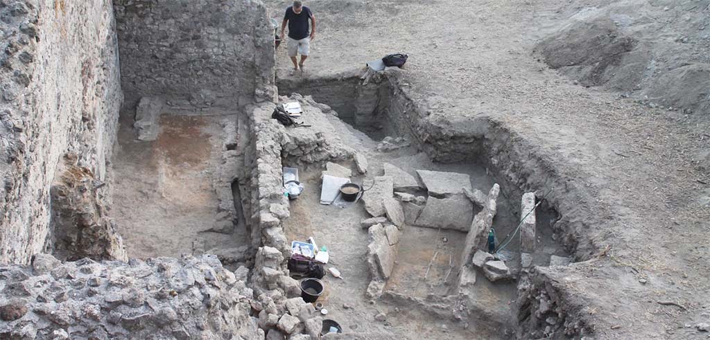 HG31A Pompeii. Tomb of a Samnite Woman. 2015. HGE30 left and tomb right.
The Samnite tomb was found in an area containing tombs from the Roman period, lavish villas and craftsmens shops.
It was uncovered when the wall of one of the shops was examined more closely; it was just on the other side of the partition.
No trace of the tomb cover was found.
Photograph  L.CAVASSA/CNRS-AMU .

