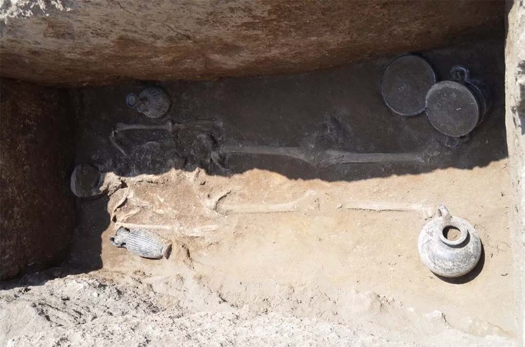 HGE32A Pompeii. June 2016. Tomb of a Samnite Man. The distribution is as follows: 
there is an oenochoe lying against the right arm, a lekythos in a vertical position near the left arm, then three vases next to the left leg: a cup on a high foot, a kylix, and a skyphos, while near the right leg, there was a jug. 

La rpartition est la suivante : 
on retrouve une oenochoe en position allonge contre le bras droit, un lcythe en position verticale  proximit du bras gauche, puis trois vases  ct de la jambe gauche : une coupe sur haut pied, une kylix, et un skyphos, tandis qu proximit de la jambe droite, se trouvait une cruche. 

See Pompi, Porta Ercolano : organisation, gestion et transformations dune zone suburbaine: Campagne 2016 CEFR 1676 and below.

Photograph  Parco Archeologico di Pompei.

